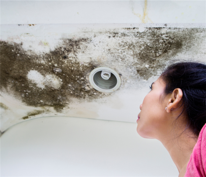 Woman looking up at mold on the ceiling