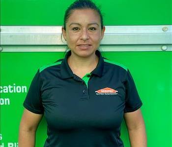 Female SERVPRO employee smiling in front of a green background